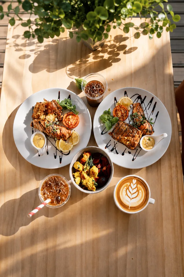Coffee, iced drinks and brunch dishes on a sunlit table