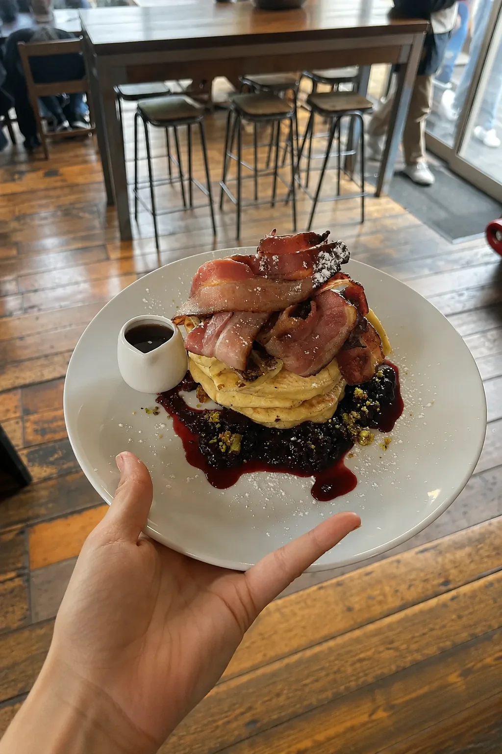 Pancakes topped with bacon and berries at Good Habit
